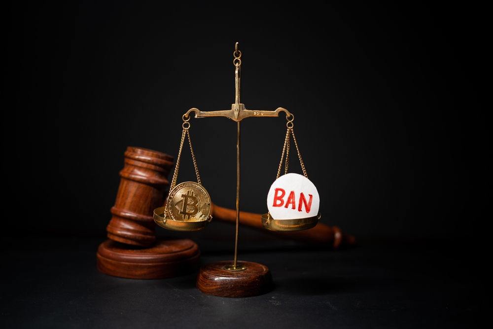 concpet of cryptocurrency ban showing with Bit coin and ban sybmol on balance scale with judge hammer on background.