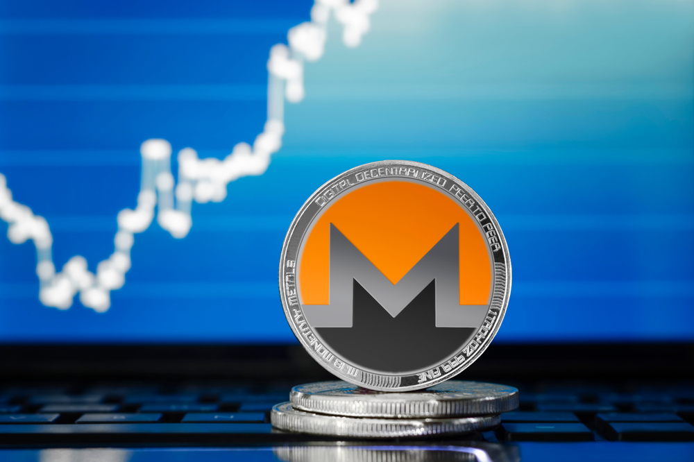 MONERO (XMR) cryptocurrency; silver monero coin on the background of the chart