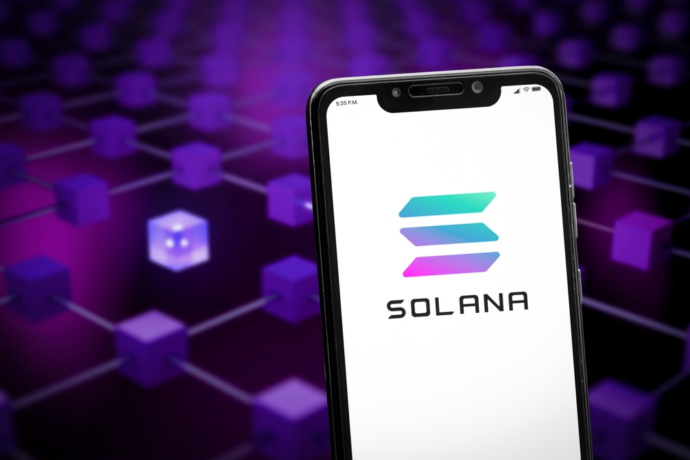 Solana logo on the smartphone screen and the concept of blockchain at the blurred background.
