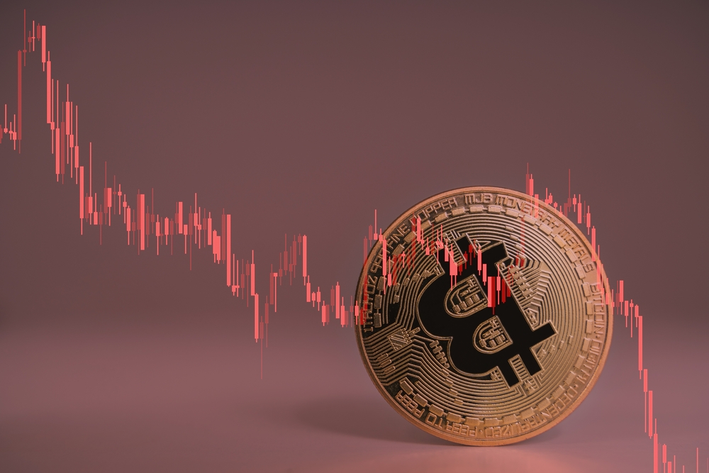 Closeup Bitcoin cryptocurrency upside down when Bitcoin price crash falling down, price, volume in stock market decrease for any risk with red trading price graph chart.