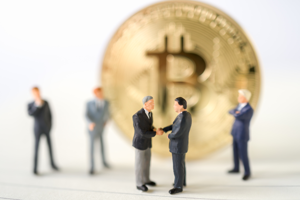 Miniature businessman handshake success deal business with Gold bitcoin background commitment