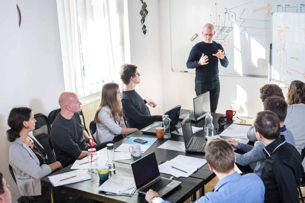 Relaxed informal IT business startup company meeting. Team leader discussing and brainstorming new approaches and ideas with colleagues.