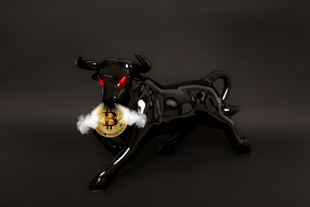 Bullish trend of Bitcoin crypto currency. Bitcoin gold coin and black bull. Virtual cryptocurrency concept. Black background.