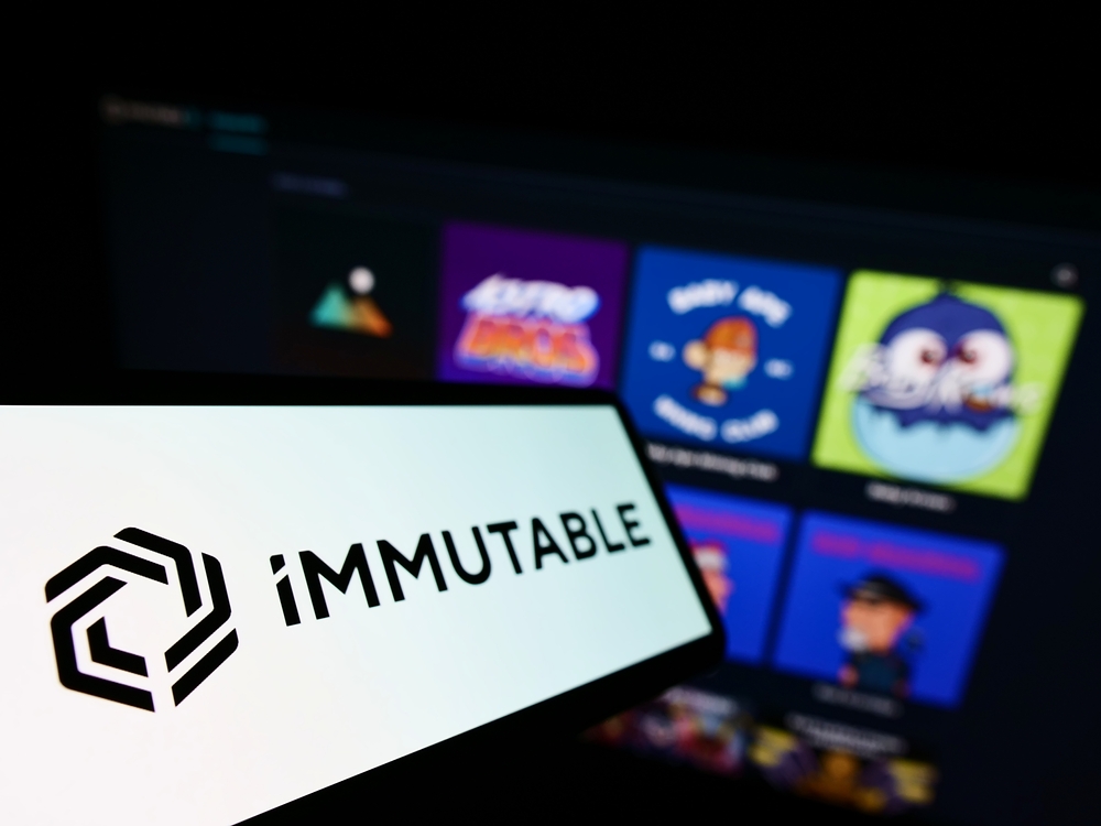 Smartphone with logo of Australian blockchain company Immutable Pty. Ltd. on screen in front of business website.