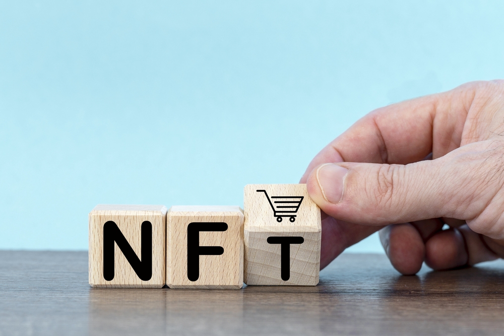 Wooden cubes with word NFT. hand, trolley.buying and sale type of cryptographic nft tokens.