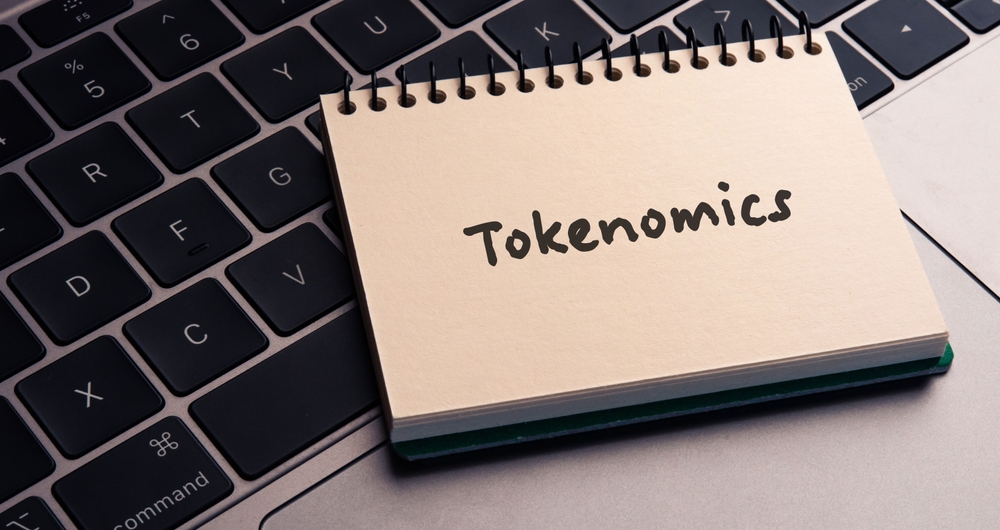 There is notebook with the word Tokenomics. It is as an eye-catching image.