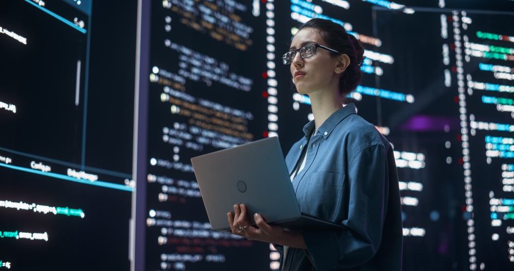 Portrait of Woman Creating a Software and Coding, Surrounded by Big Screens Displaying Lines of Programming Language Code. 