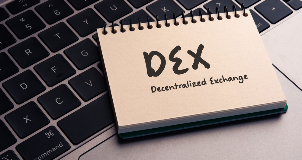 There is note book with the word DEX (Decentralized Exchange) on a laptop.