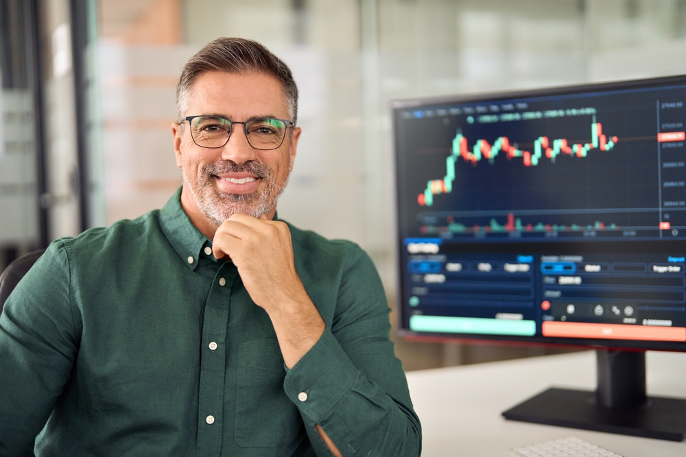 Happy middle aged business man stock investor or broker, smiling mature trader or financial expert advisor at work, stockbroker portrait.