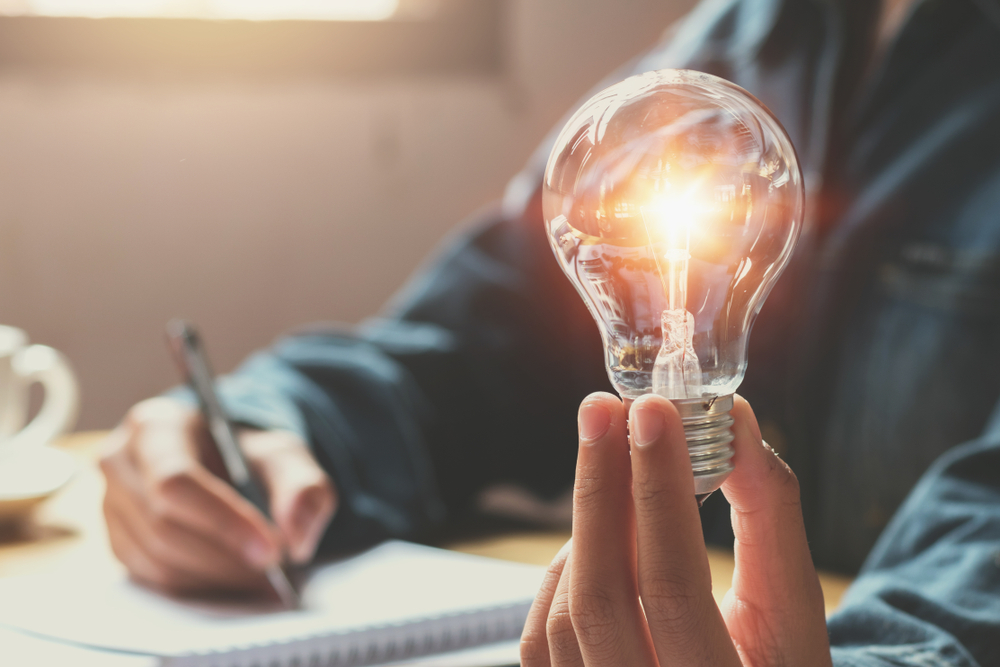 new idea and creative concept for business woman hand holding light bulb