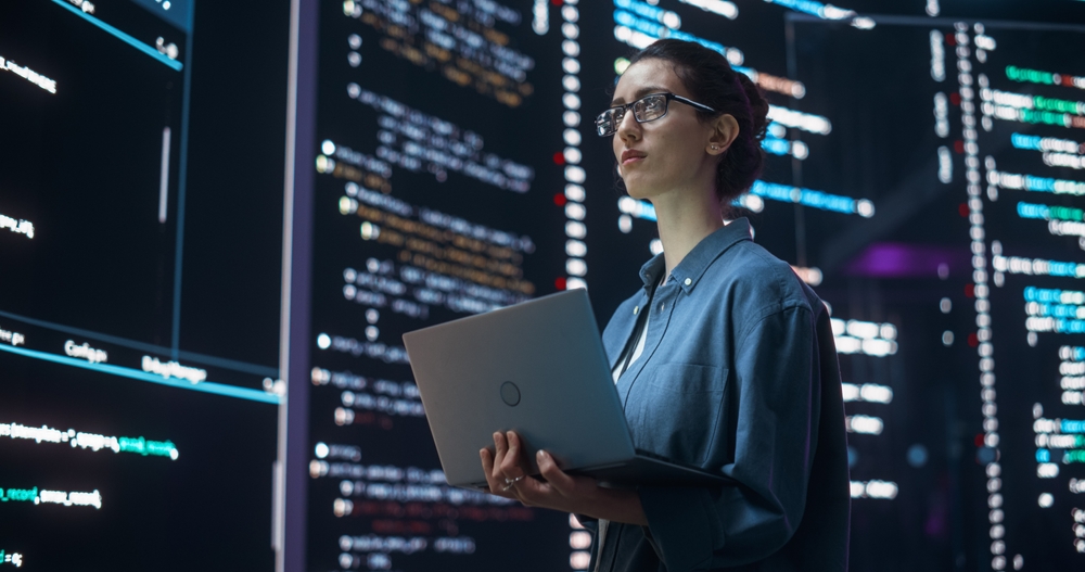 Portrait of Woman Creating a Software and Coding, Surrounded by Big Screens Displaying Lines of Programming Language Code.