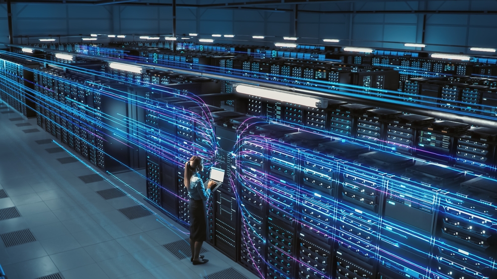 Big Data Center Female Chief Technology Officer Using Laptop Standing In Warehouse