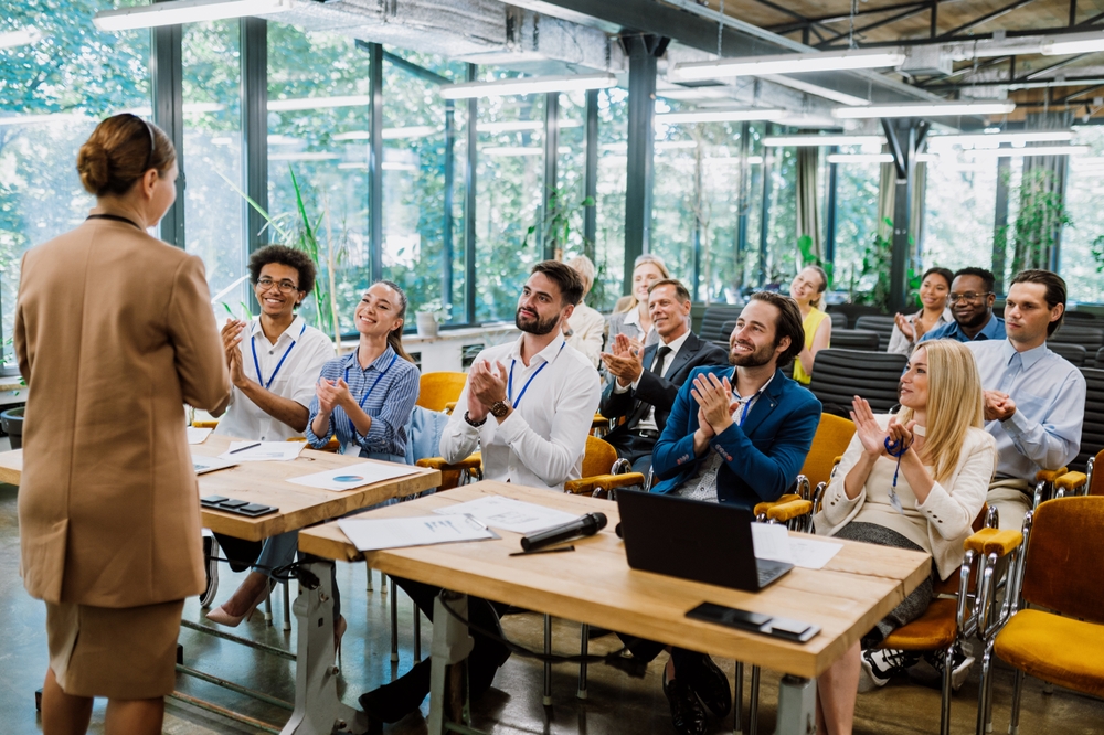 Cinematic image of a conference meeting. Business people sitting in a room listening to the motivator coach. 