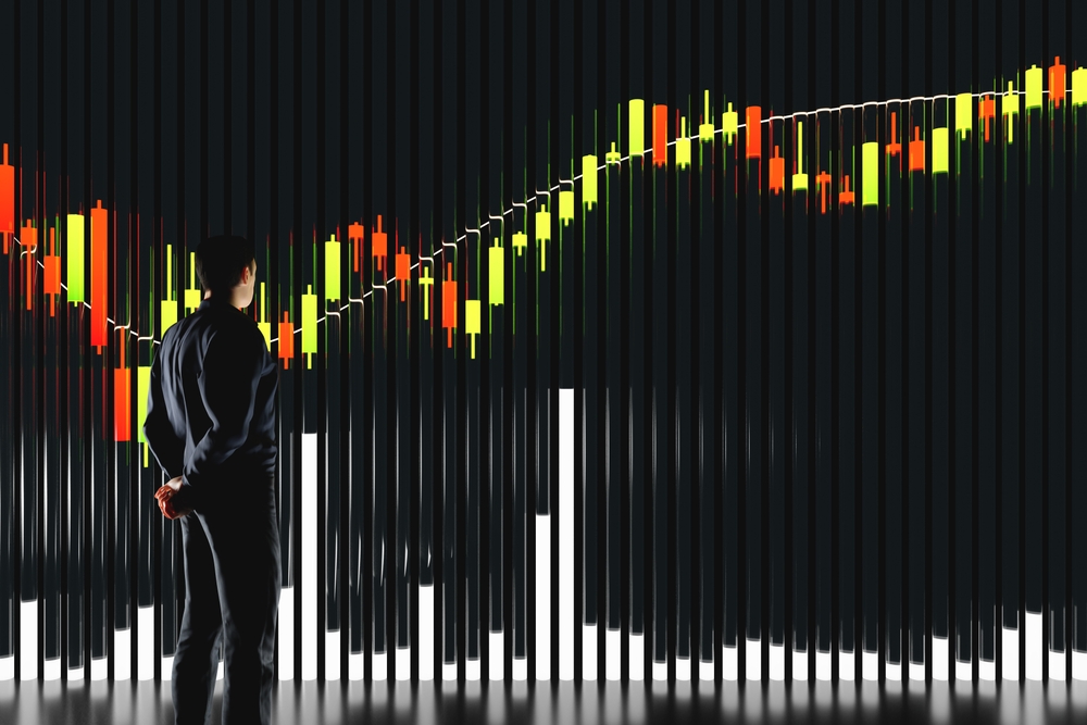 Price chart with volumes. The trader analyzes the price movement on a huge trading chart. A businessman-investor watches the movement of the price of an asset.