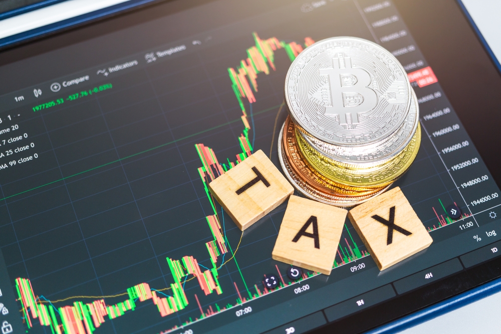 Cryptocurrencies with TAX word and stock chart candlestick on tablets background, Digital money concept