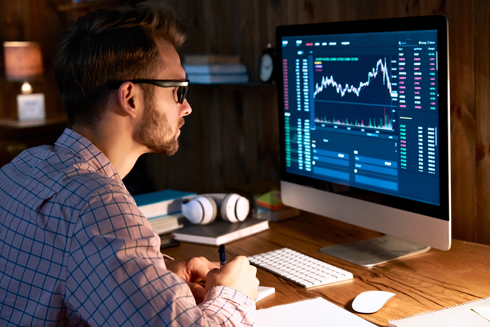 Serious business man trader analyst looking at computer monitor