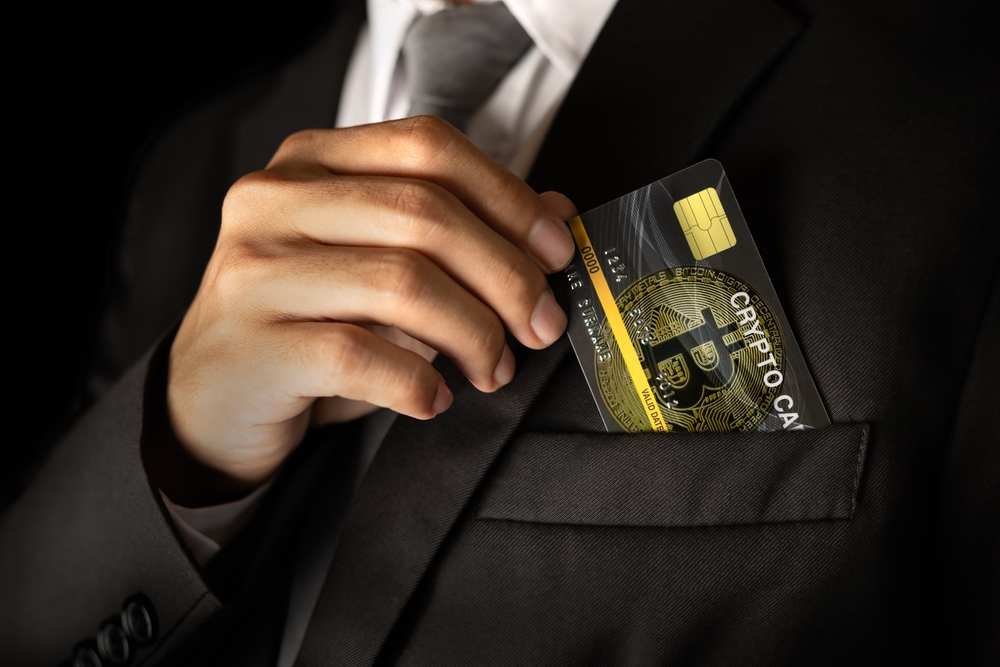 Man take out the Crypto card from the suit pocket.