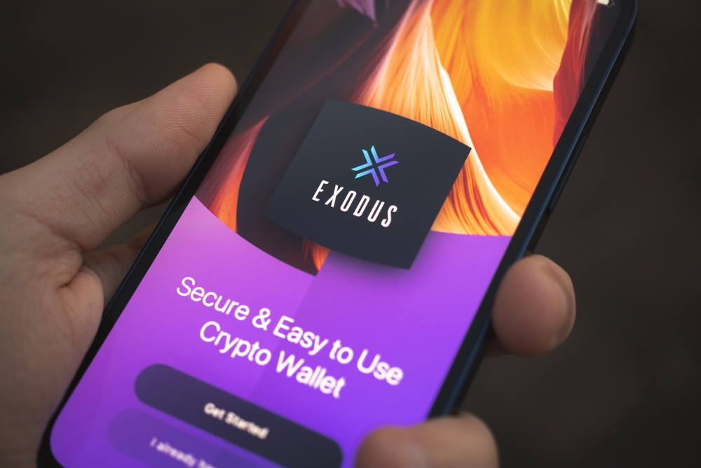 Person uses Exodus Wallet app on Apple iPhone 12. Title screen closeup, crypto and NFT concept photo