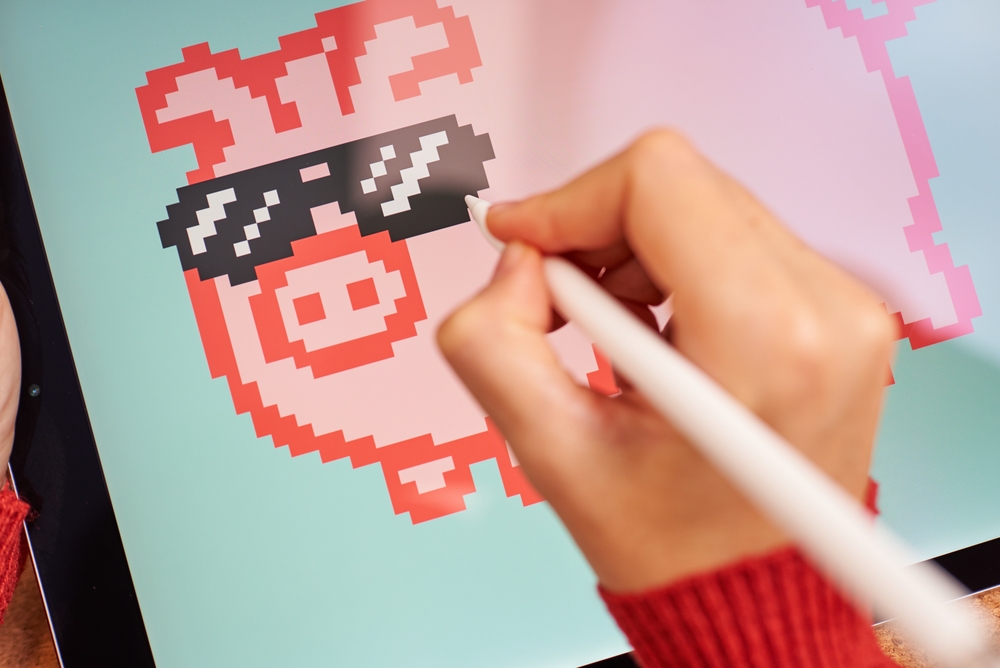 Female artist painting digitally on a tablet creating NFT