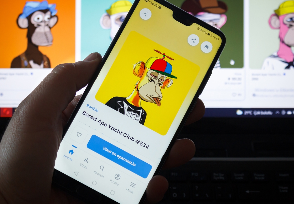 Man holding smartphone in his hand. Popular NFT website Opensea on screen. Bored Ape Yacht Club NFT collection.