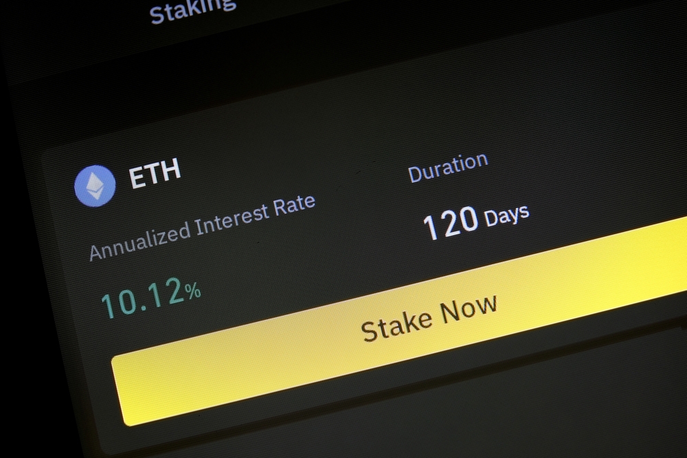 App with function to stake Ethereum for fixed interest rate and period. App allowing cryptocurrency hodlers to stake cryptos to earn rewards or interests on their holdings. Phone screen closeup view.