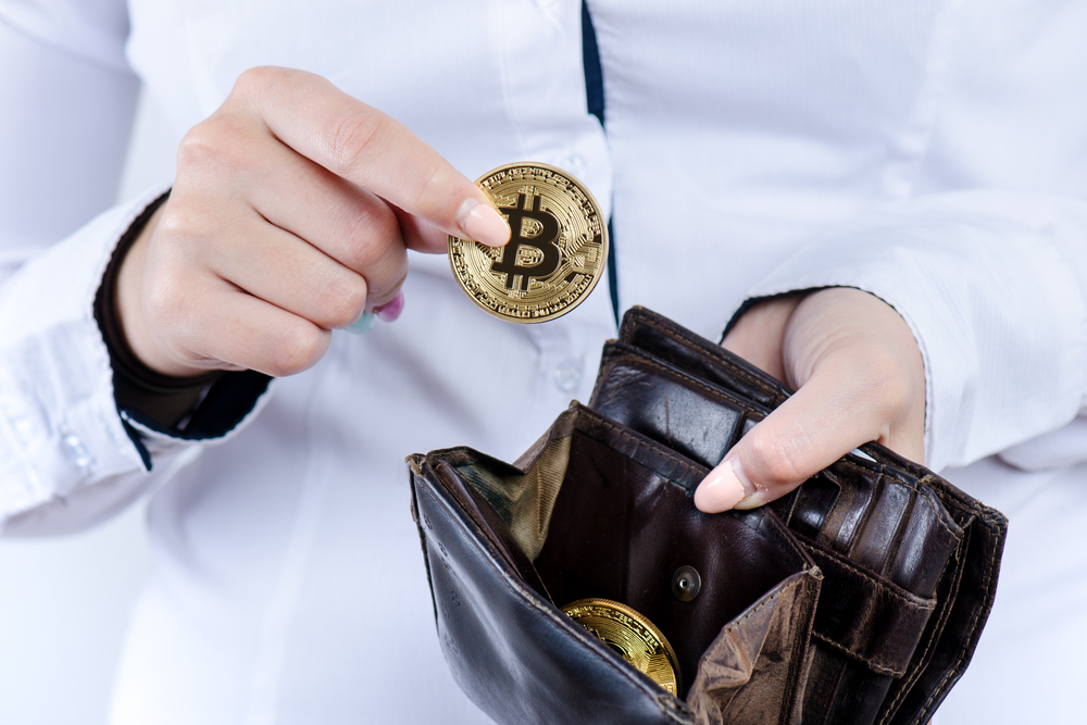 Businesswoman holding bitcoin isolated on a white background.Golden bitcoin coins in women's hands.