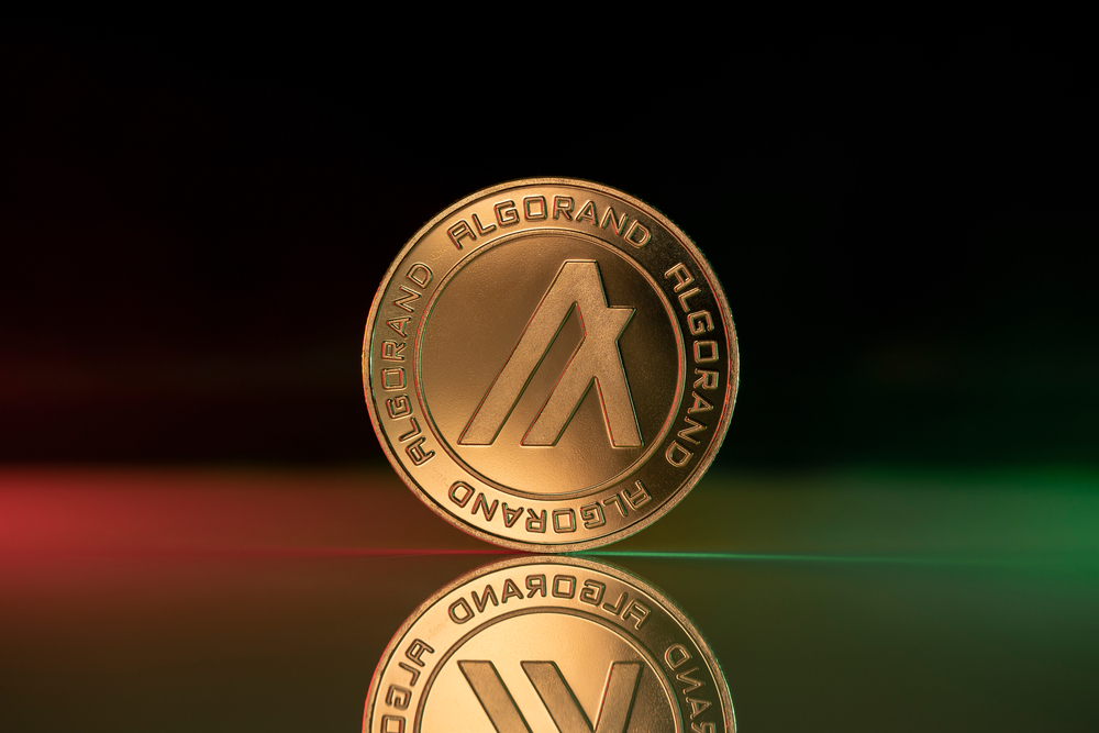 Algorand ALGO cryptocurrency physical coin placed on reflective surface and lit with green and red lights