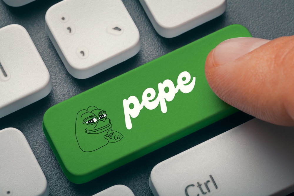 Close up photo of male hand finger pressing pepe memecoin computer key on keyboard.