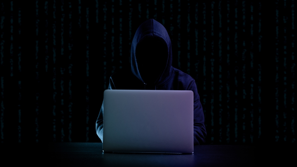 Cyber hacker attack concept. Internet web hack technology. Digital laptop in hacker man hand isolated on black.