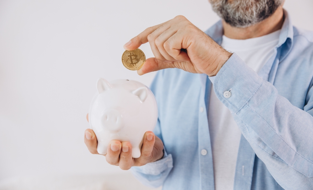 Senior man is holding piggy bank. Elderly male with coin, bitcoin