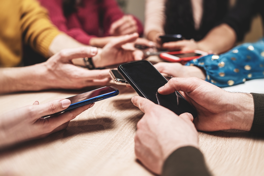 Group of friends using smartphones - social media interaction - digital connection - technology addiction, group activity - mobile phones, modern communication.