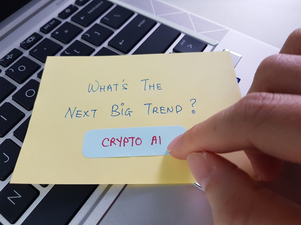 Finger pointing at a sticky note with the words What Is the net big trend crypto artificial intelligence
