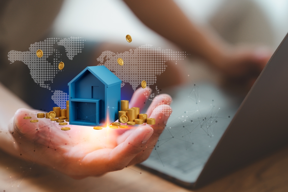 A hand holding a 3D house model surrounded by coins and a world map, symbolizing real estate investment, global business, and financial growth opportunities.