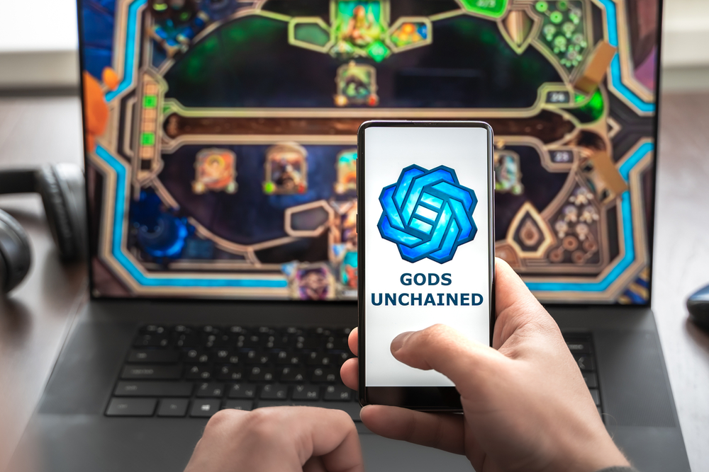 Logo, screenshot of blockchain nft ethereum cryptocurrency game Unchained gods in laptop.