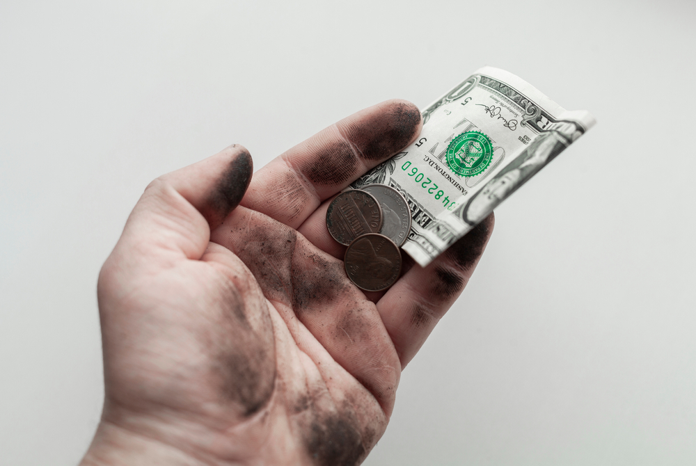 coins money in dirty hand on white background, poverty concept