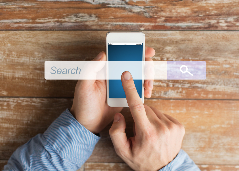 business, people, internet and technology concept - close up of male hands holding smartphone and pointing finger browser search bar