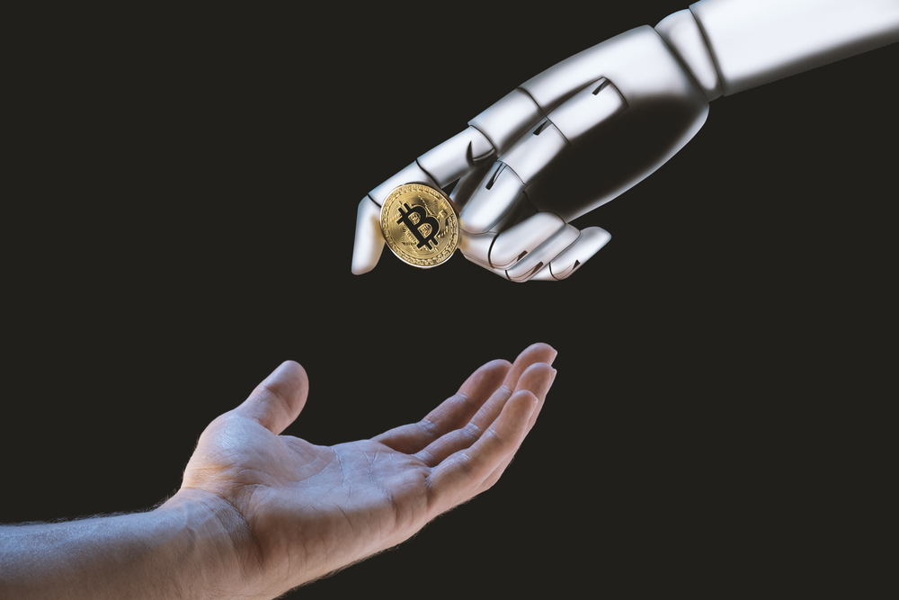 Robot hand giving a Bitcoin to an human hand on a black background.